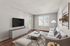 Modern living room with elegant decor, featuring a plush sofa, large TV, and natural light streaming through windows.