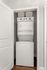 Compact laundry area showcasing a modern stacked washer and dryer with convenient storage baskets above.