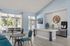 Elegant kitchen and living area with large windows, modern decor, and poolside view, offering a serene and stylish ambiance.