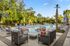 Luxurious outdoor pool with stylish lounge chairs, surrounded by lush greenery and elegant seating areas.
