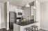 Modern kitchen with sleek stainless steel appliances, elegant pendant lighting, and a stylish breakfast bar with seating.