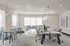 Bright and modern office space with sleek workstations, stylish seating area, and elegant pendant lighting.