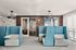 Modern coworking space with stylish blue and gray seating pods, elegant lighting, and vibrant wall art for a dynamic work environment.