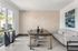 Bright modern dining area with elegant table, stylish chairs, and artistic wall decor next to a sunlit window.