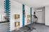 Modern grooming room with sleek stainless steel sink, stylish blue and white tiled wall, and practical wooden shelving.
