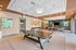 Modern recreational room featuring a sleek ping-pong table, cozy seating area, and stylish decor under a beautifully designed ceiling.