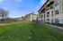 Charming apartment complex surrounded by lush green lawns and modern architecture under a clear blue sky.