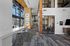 Sleek modern lobby with high ceilings, large windows, and stylish pendant lighting, featuring a long white counter with rustic stools, perfect for meetings or casual gatherings.