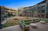 Inviting outdoor courtyard with stylish string lights and comfortable seating, perfect for relaxation and social gatherings.