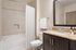 Elegant bathroom with granite countertop, modern fixtures, and luxurious bathtub in a stylish apartment.
