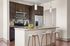 Modern kitchen with sleek granite countertops, stainless steel appliances, and elegant bar stools, ideal for entertaining.