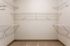 Spacious walk-in closet with ample shelving, perfect for organized storage and versatile wardrobe arrangements.