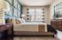 Chic and modern bedroom with designer accent wall, elegant furnishings, and ample natural light through large windows.