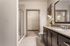 Elegant bathroom with granite countertops, large mirror, modern shower, and spacious walk-in closet.