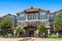 Charming three-story residential building with modern architecture, elegant facade, and lush landscaping, ideal for serene living.