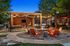 Inviting outdoor seating area with cozy fire pit, string lights, and modern wood decor, perfect for evening relaxation.