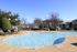 Inviting outdoor swimming pool with sun loungers and umbrellas, perfect for a relaxing day under the clear blue sky.
