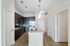 Contemporary kitchen featuring sleek dark wood cabinets, a stylish island with a modern sink, and elegant lighting.