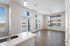 Bright open-concept living area featuring elegant hardwood floors, large windows, and modern kitchen with sleek countertops.