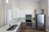Modern kitchen with sleek stainless steel appliances, elegant white cabinetry, and a stylish glass tile backsplash, offering a contemporary and functional space.