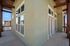Modern apartment balcony with elegant wooden beams and large windows, offering scenic views and abundant natural light.