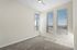 Bright and airy room featuring expansive windows with a stunning view, fresh carpeting, and a sleek ceiling fan.
