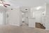 Bright and inviting apartment interior with plush carpeting, modern kitchen, and ample natural light through large windows.