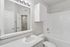 Bright and modern bathroom with sleek white fixtures, illuminated vanity mirror, and a pristine bathtub. Perfect blend of style and functionality.