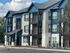 Charming modern apartment building with spacious balconies and elegant blue accents, nestled in a serene environment.