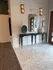 Elegant apartment entrance with stylish console table, modern decor, and chic lighting.