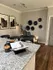 Chic kitchen and dining area with granite countertops, modern decor, and elegant wall art, perfect for stylish living.