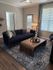 Chic living room with elegant dark blue sofa, modern decor, and inviting natural light.