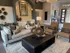 Elegant living room featuring a plush sofa, stylish armchairs, and contemporary decor with warm lighting and artistic wall accents.
