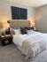 Elegant bedroom with plush bedding, modern decor, and warm lighting creating a cozy ambiance.