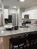 Modern kitchen with granite countertops, sleek white cabinets, and stylish appliances offering a chic and inviting cooking space.