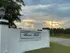 Charming entrance to Rose Hill with elegant signage and a picturesque sunset backdrop.