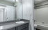 Modern bathroom with sleek countertop, large mirror, and pristine bathtub, perfect for relaxation and convenience.