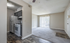 Bright and welcoming apartment interior featuring an open-concept living area with carpeted floors, adjoining modern kitchen, and large sliding glass doors leading to a balcony.