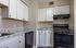 Modern kitchen with sleek granite countertops, white cabinetry, and stainless steel appliances.