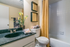 Charming bathroom with elegant countertop, stylish mirror decor, and vibrant yellow accents creating a refreshing ambiance.