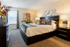 Inviting bedroom showcasing a luxurious bed with vibrant pillows, stylish decor, and abundant natural light.