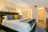 Cozy bedroom with elegant decor, featuring a plush king-sized bed adorned with colorful cushions and modern bedside lighting.