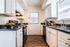 Charming and bright kitchen with sleek countertops, shiny stainless steel appliances, and elegant cabinetry, offering a warm and inviting space.