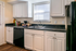 Bright and modern kitchen with sleek black countertops, contemporary white cabinetry, and stainless steel appliances.