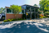 Charming apartment complex exterior with modern glass facade and lush landscaping, highlighted by vibrant balloon decorations.
