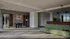 Modern office lobby featuring stylish geometric seating, elegant wall art, and conference room access.