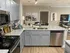 Modern kitchen with sleek countertops, stainless steel appliances, and open view to an elegant dining and living area.