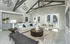 Modern living room with elegant decor, featuring a stylish sofa, chic lighting fixtures, and a patterned accent wall, offering a cozy yet sophisticated atmosphere.
