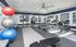 Bright, modern gym room equipped with treadmills, exercise bikes, and fitness balls, complemented by large windows and a sleek design.