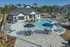 Luxurious apartment complex featuring a sparkling resort-style pool, elegant lounging areas, and modern clubhouse surrounded by lush greenery.